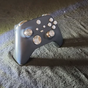 Silver gaming controller on textured surface.